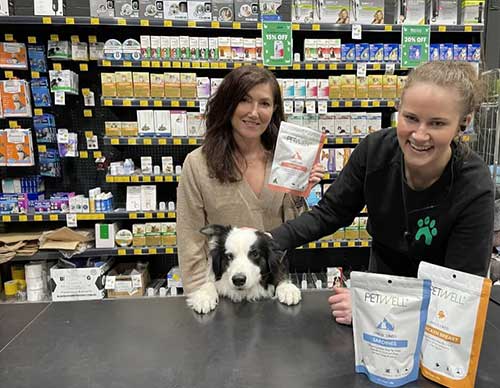 Ayda & Archie behind counter at Habitat store with staff and PetWell treats